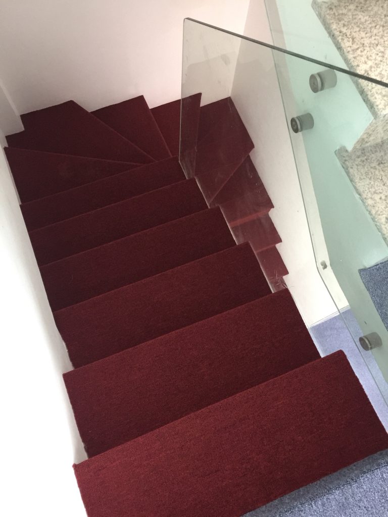 Cầu thang sáng tạo được bỏng thảm màu đỏ tạo nên sự đối lập hài hòa